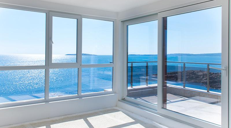 Ventanas de PVC y aluminio resistentes al salitre instaladas en una vivienda moderna frente al mar.